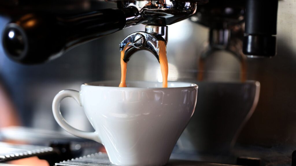 Cup of coffee being brewed with a professional machine