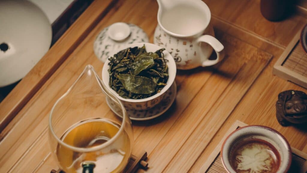 White ceramic tea pots with tea leaves
