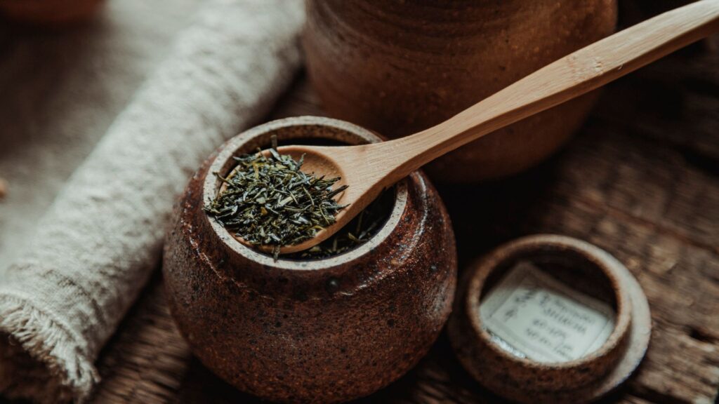 Dried tea and herbs on a wooden spoon